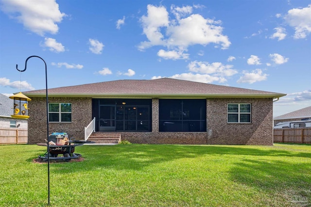 back of property with a lawn and a sunroom