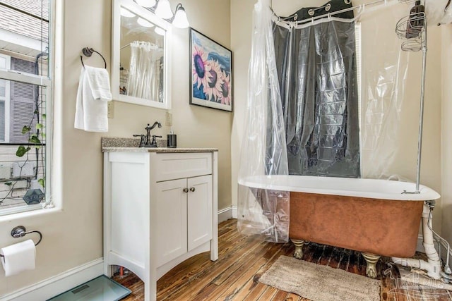 bathroom featuring vanity, hardwood / wood-style flooring, and plus walk in shower