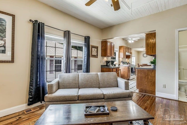 living room featuring dark wood-type flooring and ceiling fan