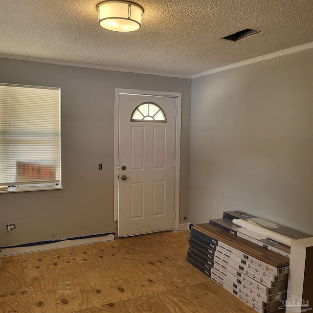 entryway featuring a textured ceiling and crown molding