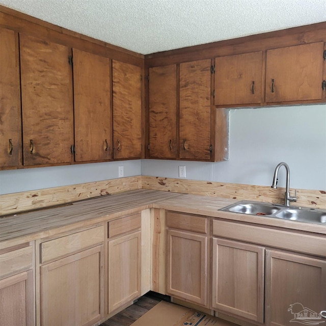 kitchen featuring dark hardwood / wood-style floors, a textured ceiling, sink, and butcher block countertops