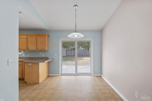 kitchen featuring baseboards, pendant lighting, and dark countertops