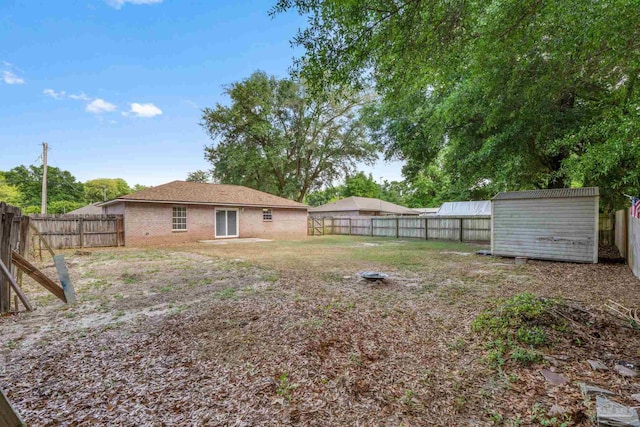 view of yard featuring a fenced backyard, an outbuilding, and a storage shed