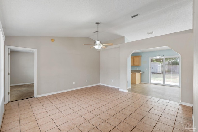 empty room featuring visible vents, baseboards, ceiling fan, arched walkways, and vaulted ceiling