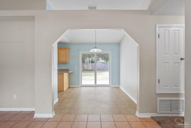 unfurnished dining area with light tile patterned floors, baseboards, and visible vents