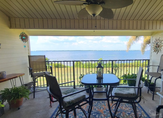 balcony with a water view and a ceiling fan