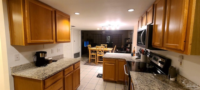 kitchen with light tile patterned floors, appliances with stainless steel finishes, recessed lighting, and brown cabinets