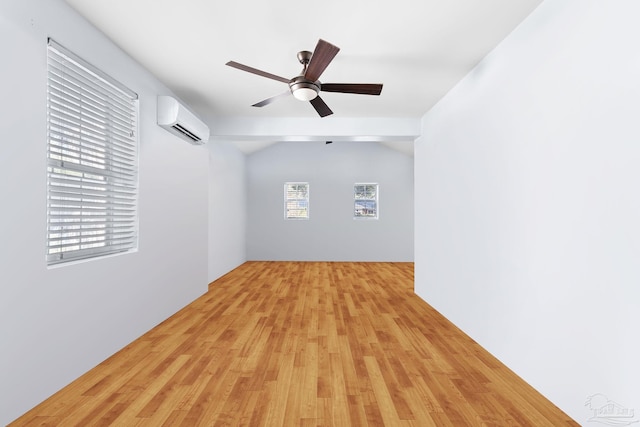 spare room featuring an AC wall unit, ceiling fan, and light hardwood / wood-style floors