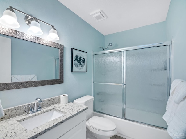 full bathroom with toilet, vanity, and shower / bath combination with glass door