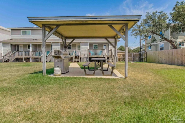 rear view of property featuring a wooden deck, a yard, and a patio