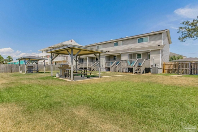 back of property featuring a gazebo, a yard, central AC unit, and a deck