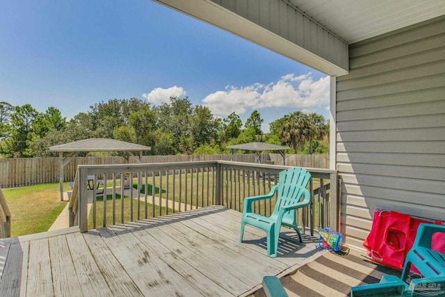 wooden deck featuring a gazebo and a yard