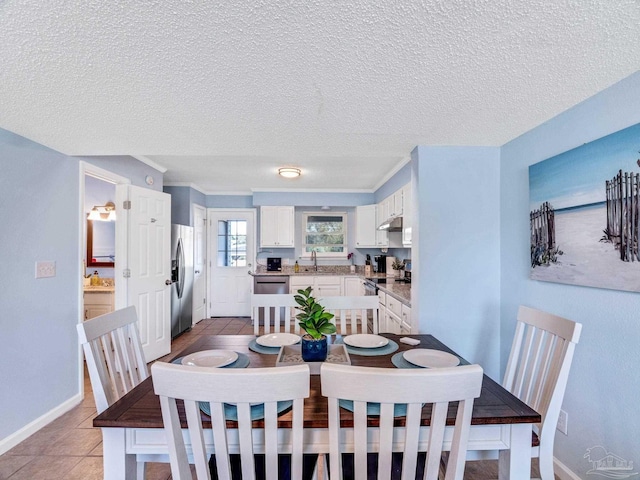 dining room featuring light tile patterned floors, sink, and a textured ceiling