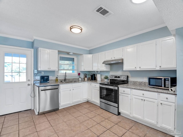 kitchen featuring appliances with stainless steel finishes, sink, light tile patterned floors, and white cabinets