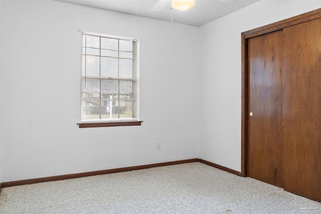 unfurnished room featuring carpet flooring and a textured ceiling