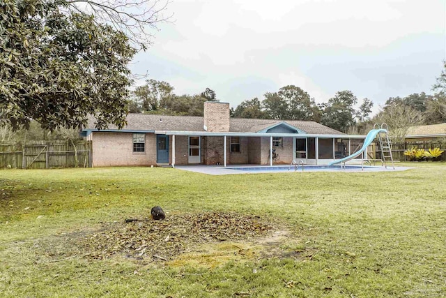 back of house featuring a lawn and a patio area