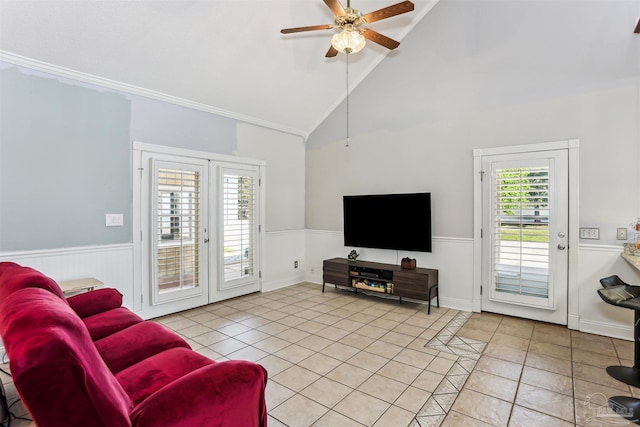 living room with a ceiling fan, wainscoting, and light tile patterned flooring
