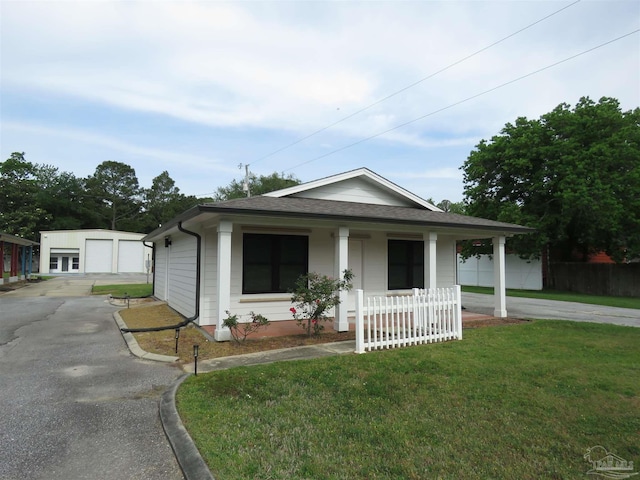 bungalow featuring covered porch, fence, roof with shingles, and a front lawn
