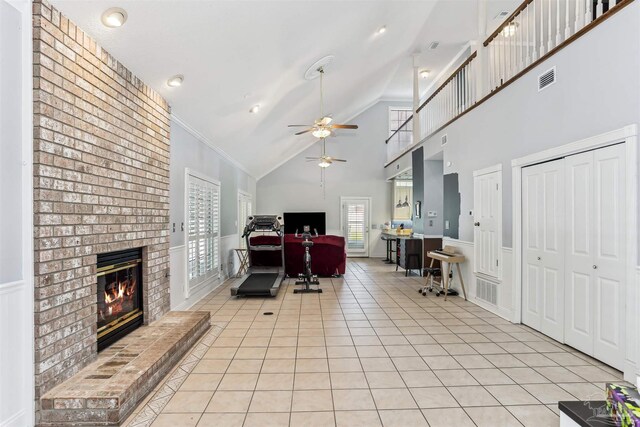 living room with visible vents, light tile patterned flooring, a fireplace, high vaulted ceiling, and a ceiling fan