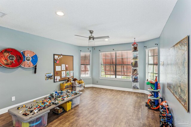 rec room featuring a ceiling fan, baseboards, and wood finished floors