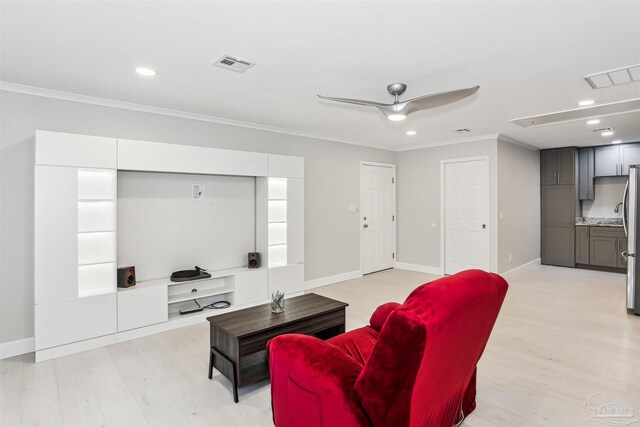 living area with crown molding, light wood-style flooring, and visible vents