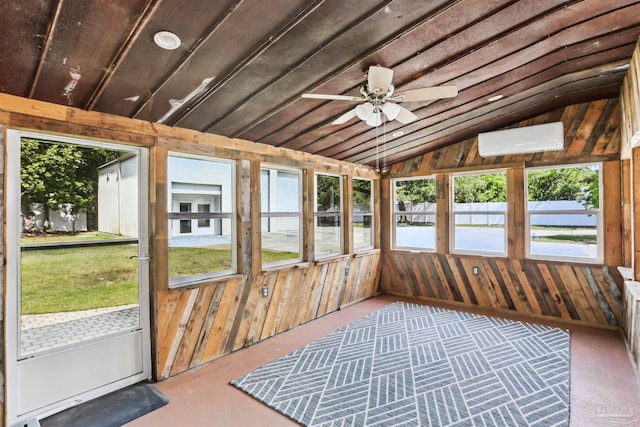 unfurnished sunroom featuring ceiling fan, a wall mounted AC, and a healthy amount of sunlight