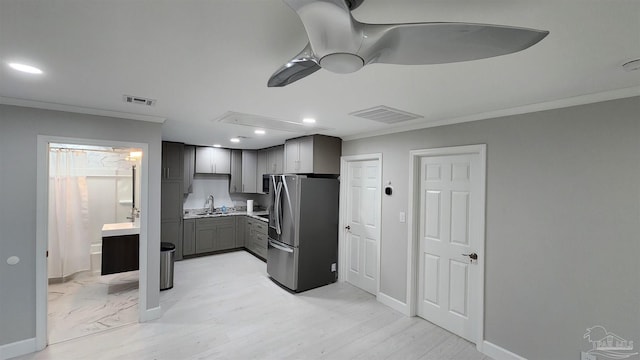 kitchen with visible vents, freestanding refrigerator, crown molding, recessed lighting, and a sink