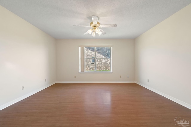 empty room with a textured ceiling, dark hardwood / wood-style flooring, and ceiling fan