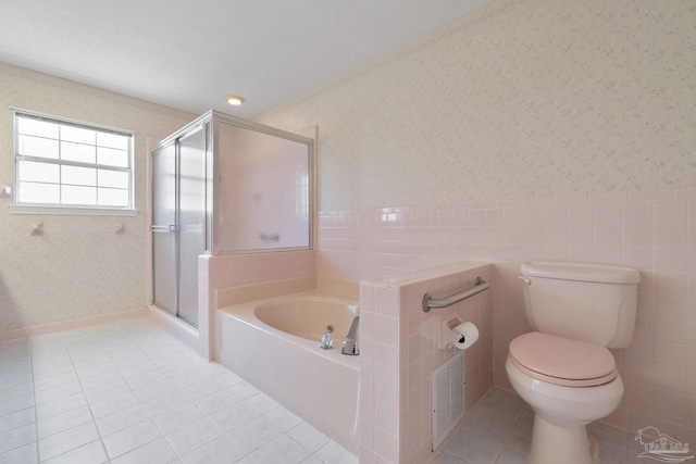 bathroom with tile patterned flooring, a textured ceiling, separate shower and tub, and toilet