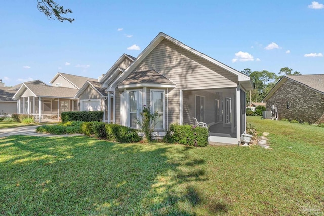 view of front of house featuring a sunroom, cooling unit, and a front yard