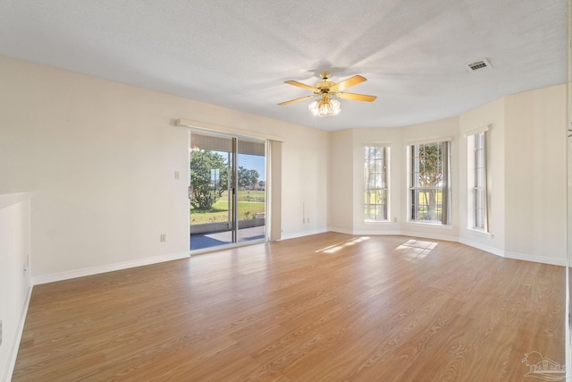 unfurnished room featuring ceiling fan, plenty of natural light, and light hardwood / wood-style flooring