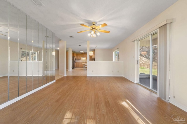 unfurnished living room featuring ceiling fan and light wood-type flooring