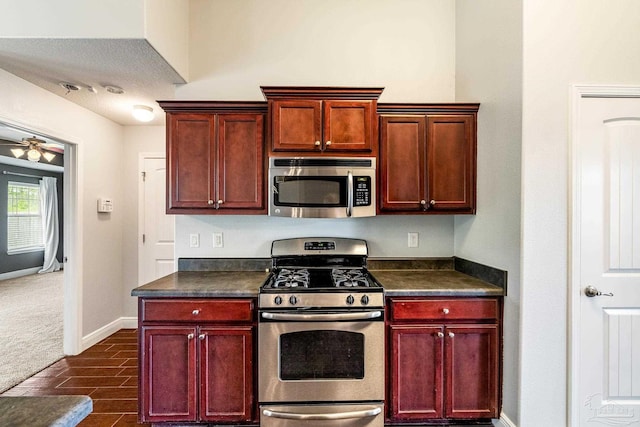11532 Aruba Dr, Pensacola, FL 32506 - kitchen with a ceiling fan, dark countertops, appliances with stainless steel finishes, dark brown cabinets, and baseboards