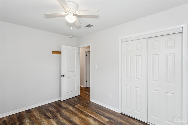 unfurnished bedroom featuring dark hardwood / wood-style floors, ceiling fan, and a closet