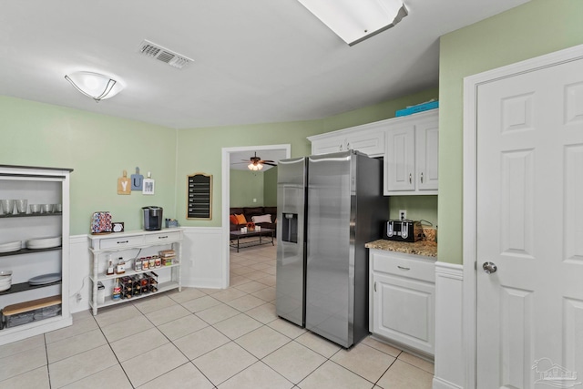 kitchen with ceiling fan, light tile patterned flooring, visible vents, white cabinets, and stainless steel fridge with ice dispenser