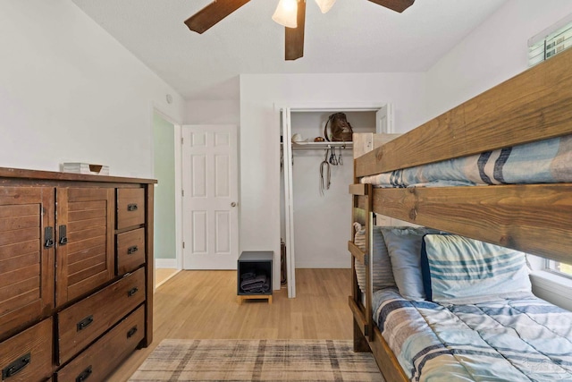 bedroom featuring light wood-style floors, ceiling fan, and a closet