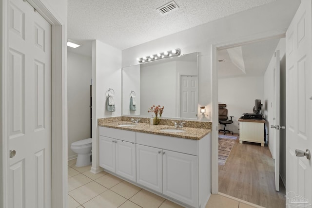 bathroom with tile patterned flooring, visible vents, a sink, and double vanity