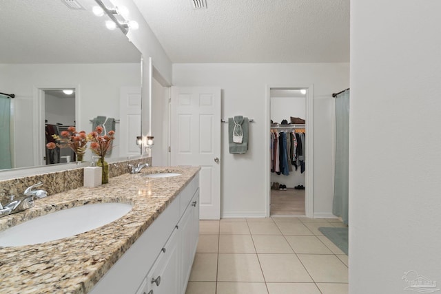 full bath featuring tile patterned flooring, a sink, a spacious closet, and double vanity