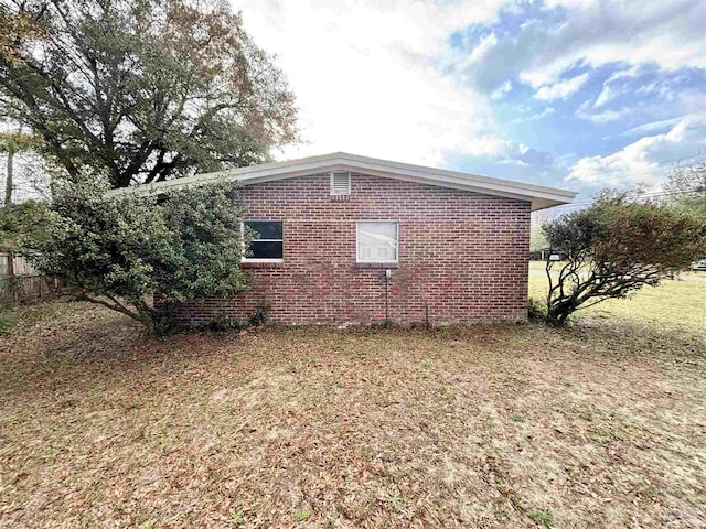 view of side of home with a yard and brick siding