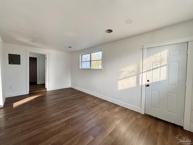 empty room featuring dark wood-type flooring and baseboards