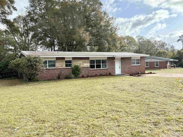 single story home featuring brick siding and a front lawn