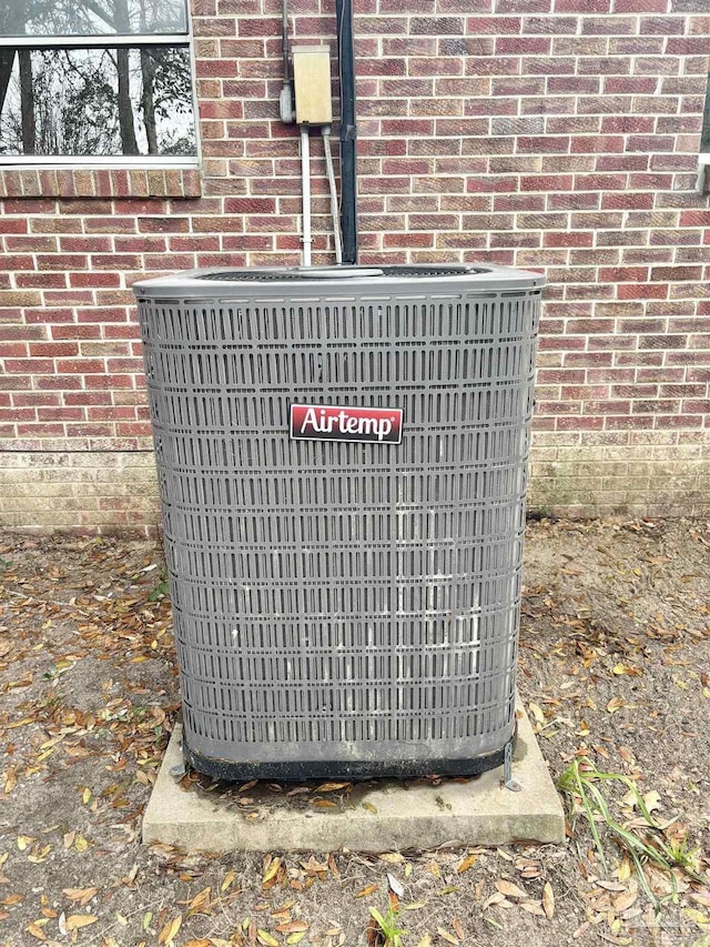 exterior details featuring brick siding and central AC