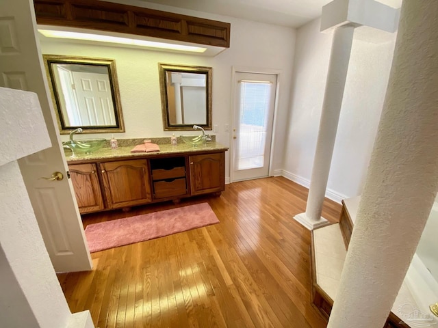 7208 Bayshore Dr, Milton, FL 32583 - full bathroom featuring wood-type flooring, double vanity, baseboards, and decorative columns