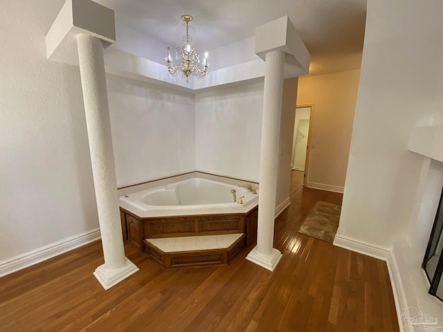 7208 Bayshore Dr, Milton, FL 32583 - full bath featuring decorative columns, a bath, wood finished floors, and baseboards