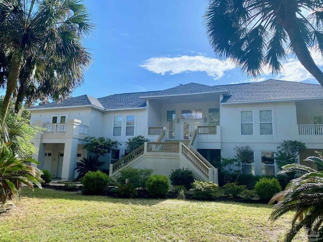 7208 Bayshore Dr, Milton, FL 32583 - view of front of house featuring stucco siding, stairs, a front yard, and roof with shingles