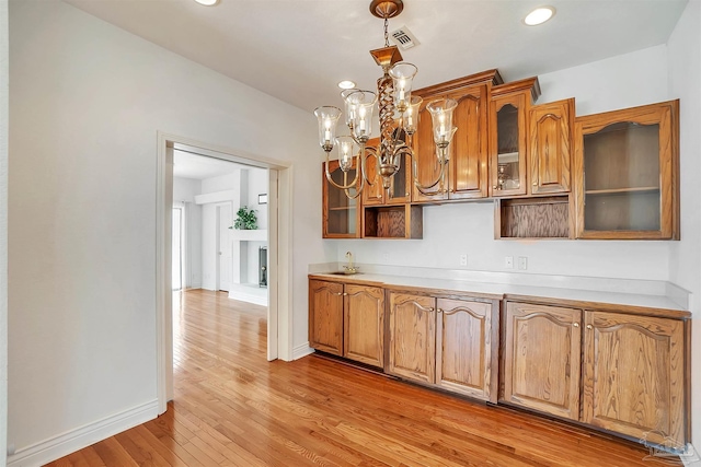 7208 Bayshore Dr, Milton, FL 32583 - kitchen featuring light wood-type flooring, baseboards, glass insert cabinets, light countertops, and recessed lighting