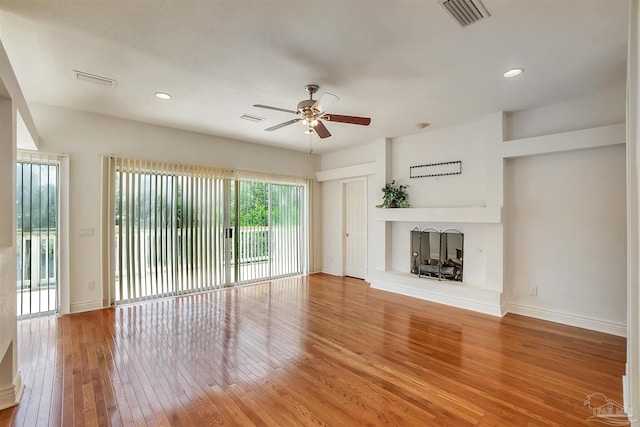 7208 Bayshore Dr, Milton, FL 32583 - unfurnished living room featuring a fireplace with raised hearth, ceiling fan, light wood-style floors, recessed lighting, and baseboards