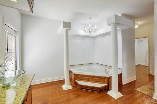 7208 Bayshore Dr, Milton, FL 32583 - bathroom with a bath, wood finished floors, baseboards, and a sink