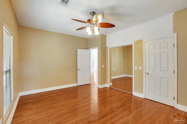 7208 Bayshore Dr, Milton, FL 32583 - unfurnished bedroom with light wood-style flooring, baseboards, a closet, and a ceiling fan