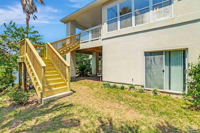 7208 Bayshore Dr, Milton, FL 32583 - view of side of home featuring stairs, stucco siding, a yard, and a wooden deck
